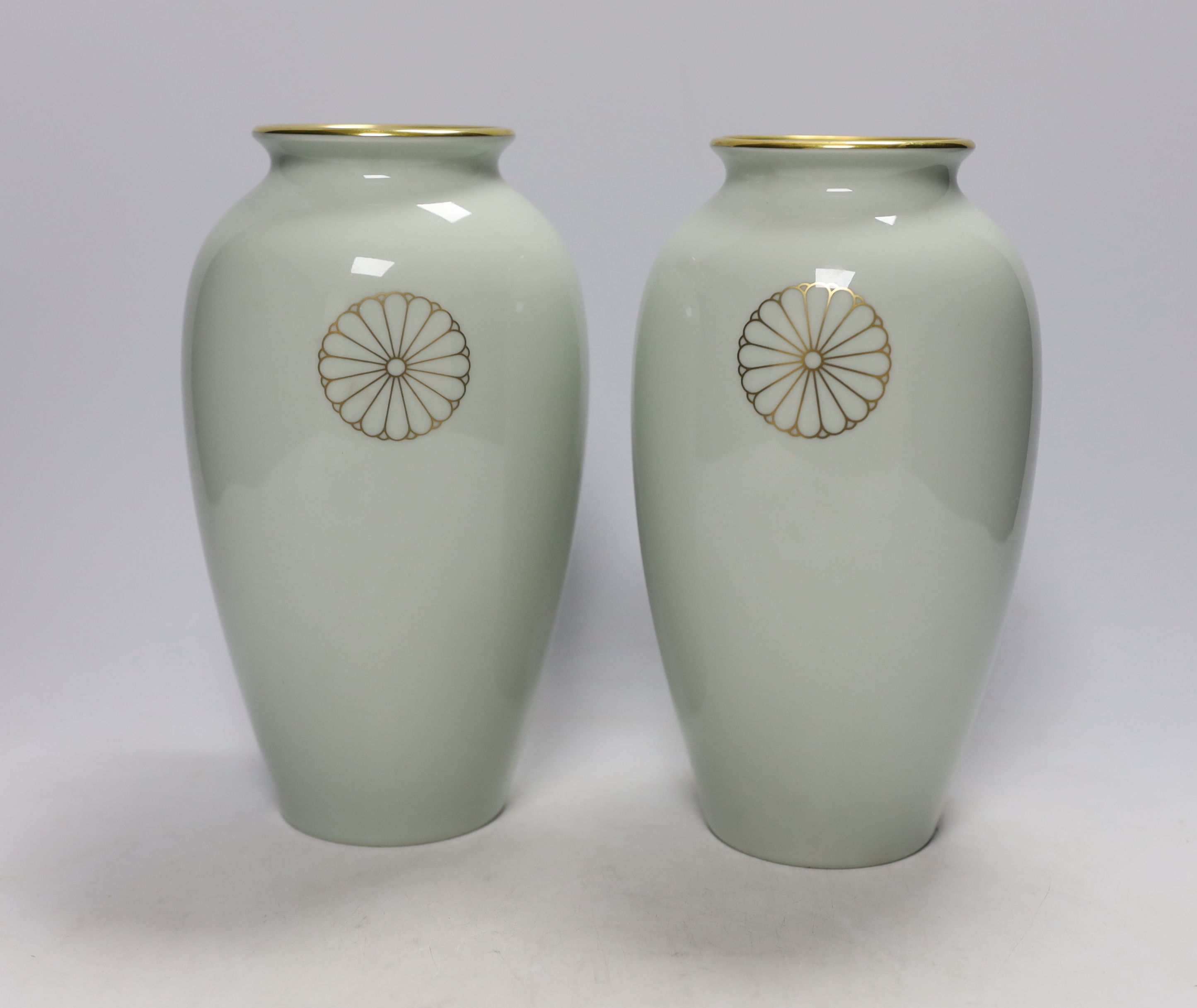 A pair of Japanese Fukagawa presentation vases, with Imperial sixteen petal chrysanthemum mon, probably a diplomatic gift, raised on hardwood stands, 25cm high